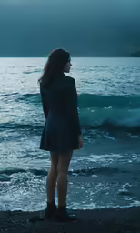 a girl in a coat and boots is looking out to the water