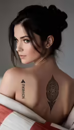 a woman with tattoos is in bed looking away