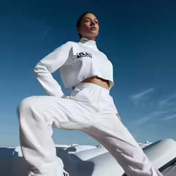 a woman poses in front of an object