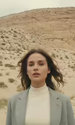 a woman standing in the desert and looking into the distance