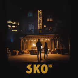 two people are standing in front of a movie theater