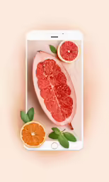 a smartphone with half a grapefruit on top