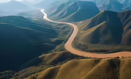 a large river running along side a lush green valley