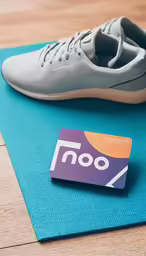 the blue yoga mat and shoe are laying on it