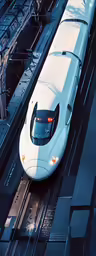 a bullet train riding on a track next to a loading platform
