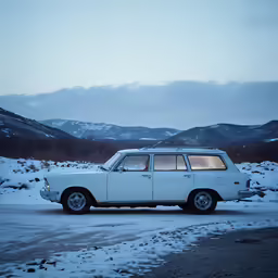 a white van sitting in the snow by some hills