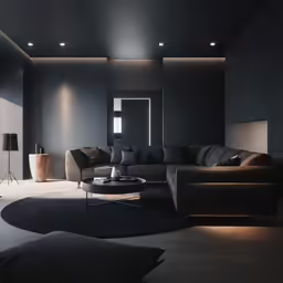 a living room has large grey couches, black furniture and a black lamp