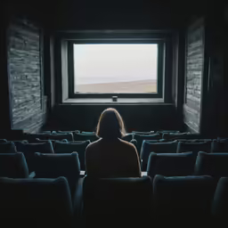 a woman watching something out of an empty window
