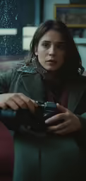 a woman sitting in a green chair holding a camera