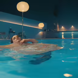 a woman swimming with balls in a pool