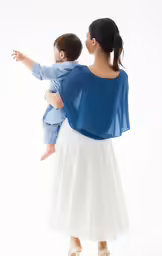 the back of a woman wearing a blue top holding a toddler