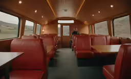 a passenger train with red leather seats and wood tables