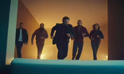 a group of people walking through a dimly lit room