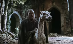 a man stands next to a llama in an area with trees and shrubs