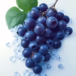 grapes and ice sitting on a table next to a green leaf