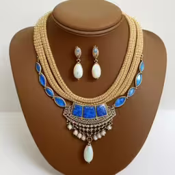 the necklace has beads and is decorated with lapis,a necklace and earrings are displayed on a mannequin,a necklace with a drop and earrings set on a mannequin,a necklace and earring set with blue beads,a white necklace, matching with some blue stones