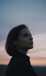 woman staring upward with sky above