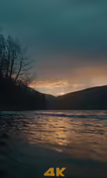 a sunset is seen as water comes close to the ground