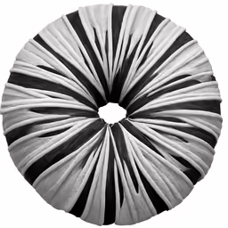 a white and black swirl pillow is laying on the floor