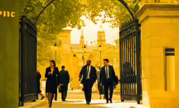 three men in suits walking down a pathway through a gate