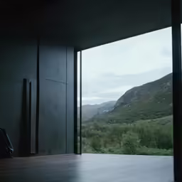 an open window with mountains in the background