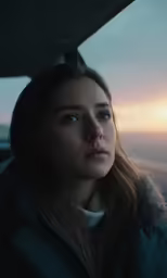 young woman looking off into distance from vehicle