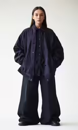 a woman standing wearing black and blue clothing