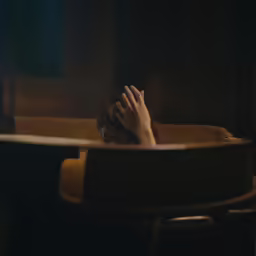 a person resting their head on her hands in a bath tub