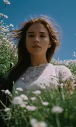 the young woman is posing in tall flowers