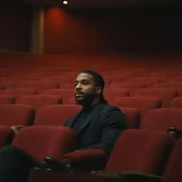 a man is in a red auditorium with his eyes open
