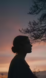 a female with the sun in the distance behind her