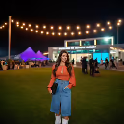the woman smiles as she stands on the grass
