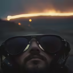 man with shades, a hat, and goggles taking a photo