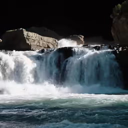 a waterfall filled with water surrounded by rocky cliffs
