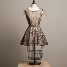 an elegant lace dress sits on a stand