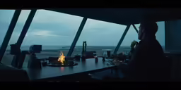 a man looks out at the ocean while sitting at his table