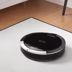 the roomba is sitting on the floor by the coffee table