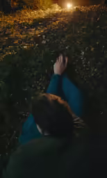 a man laying on the ground watching the night