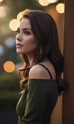 an attractive woman wearing a green top and her hair blowing in the wind