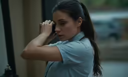 a young woman is putting her hand on her ear
