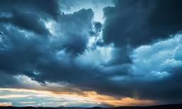 clouds are shining on the horizon and some mountains in the distance