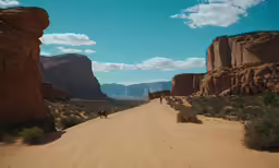 a desert road surrounded by mountains under a blue sky