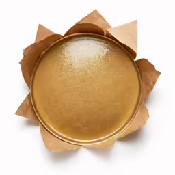 a brown container with a yellow substance on the lid