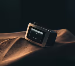 an analog device is shown sitting on a cloth