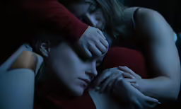 there is a woman sleeping with two hands on her head