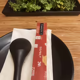 a fork laying on a table next to a napkin with a book