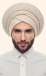 a close up shot of a man wearing a white turban