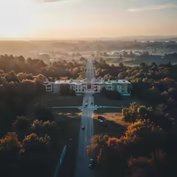 a road running through an aerial view with the setting sun in the background
