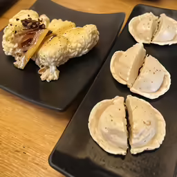four pieces of food are on black plates