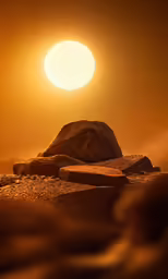 a large rock sitting on top of a sandy beach